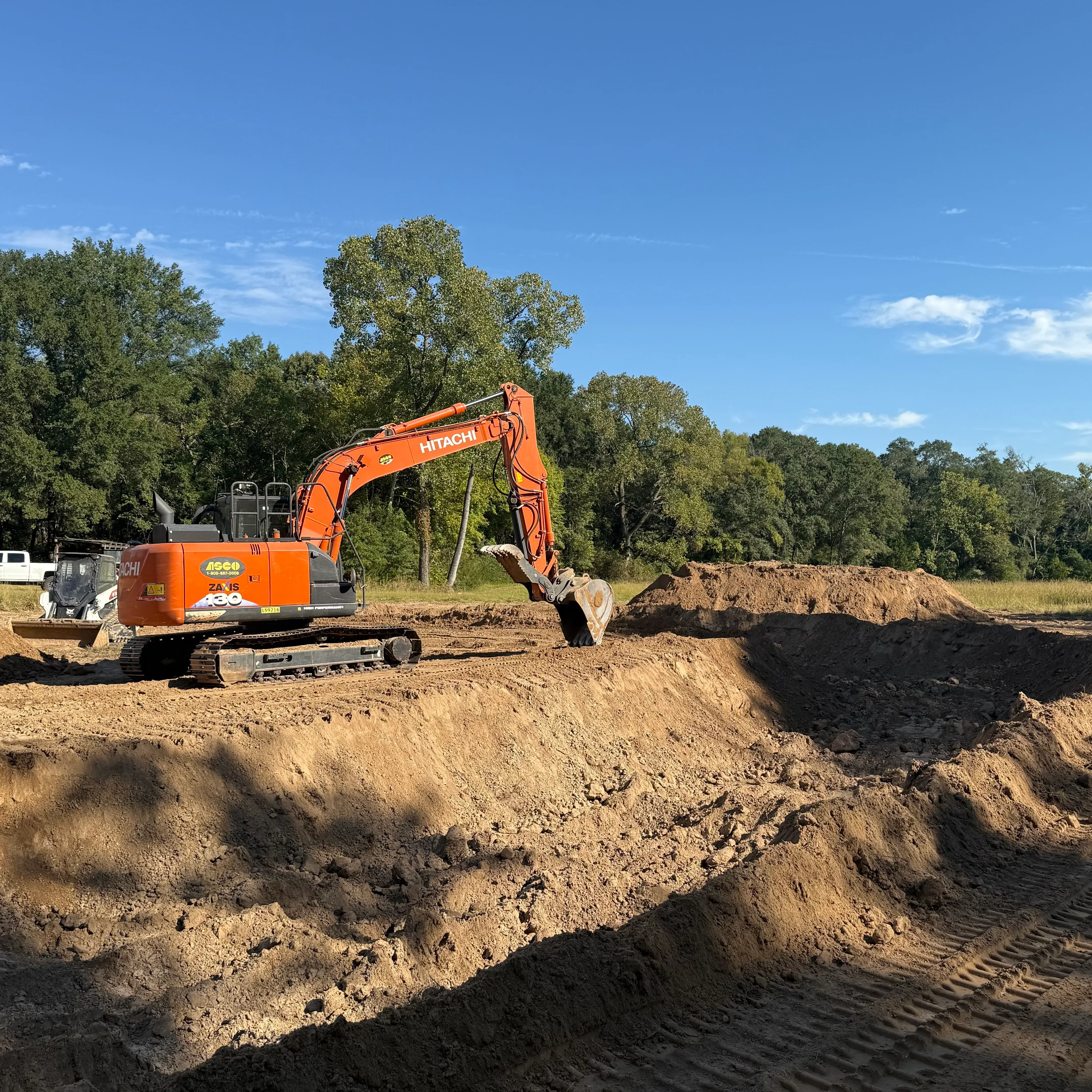 Heavy equipment clearing overgrown vegetation from a residential property