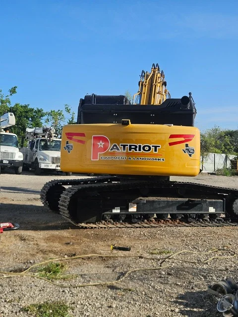 Yellow and black Patriot excavator with bucket attachment on tracked base