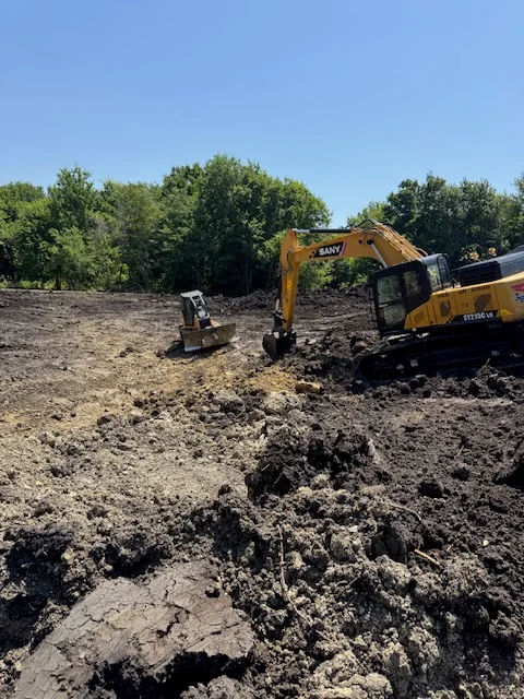 Yellow SANY excavator and compact track loader performing site excavation and soil grading
