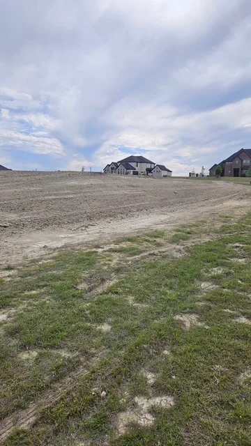 Excavated and graded residential lot with fresh grass seeding and prepared building pad