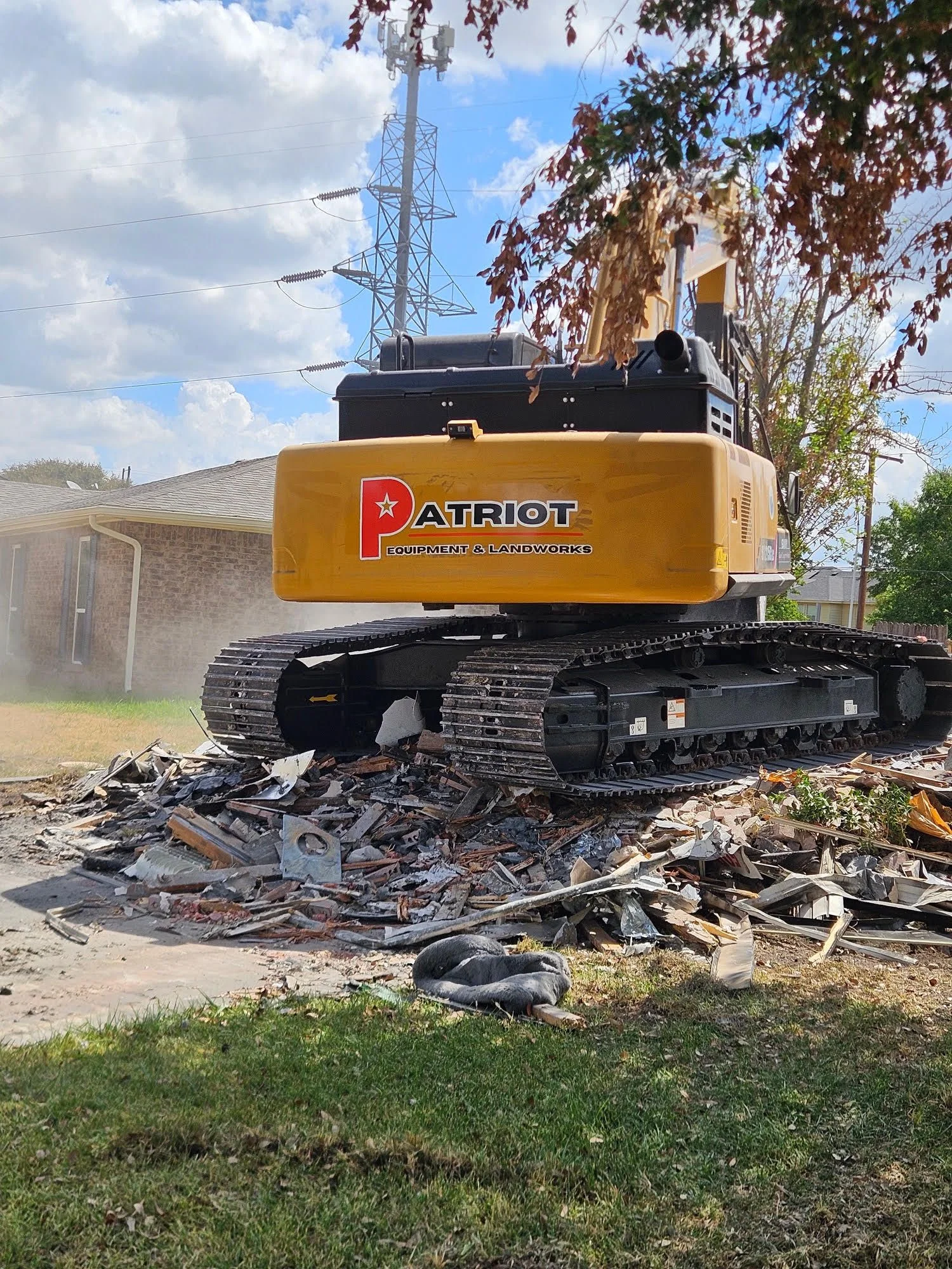 A Dallas residential lot cleared after full structure demolition by Patriot Equipment and Landworks, with debris removed and bare ground ready for new construction. Heavy equipment sits on site beside a clean, level lot in a Dallas neighborhood.